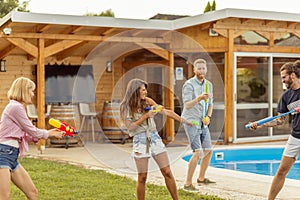 People having fun splashing water with squirt guns