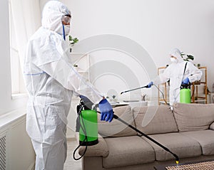 People in hazmats making disinfection in flat photo