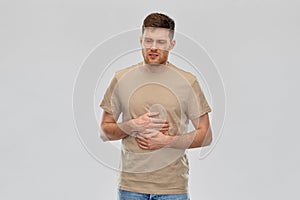 Unhappy man suffering from stomach ache photo
