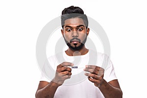 People, healthcare and fever concept - unhealthy indian man look shocked at measuring temperature by thermometer over white