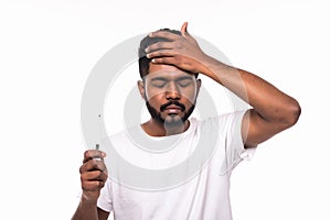 People, healthcare and fever concept - unhealthy indian man measuring temperature by thermometer over white background