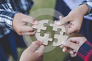 People helping in assembling puzzle, cooperation in decision making, team support in solving problems and corporate group teamwork