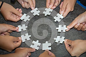 People helping in assembling puzzle, cooperation in decision making, team support in solving problems and corporate group teamwork