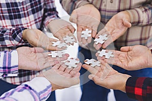 People helping in assembling puzzle, cooperation in decision making, team support in solving problems and corporate group teamwork