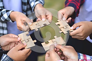 People helping in assembling puzzle, cooperation in decision making, team support in solving problems and corporate group teamwork photo