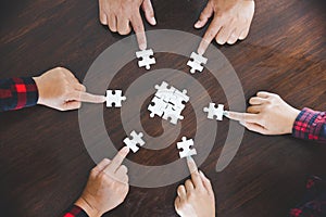 People helping in assembling puzzle, cooperation in decision making, team support in solving problems and corporate group teamwork