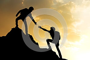 People helping on peak mountain and sunrise background climbing