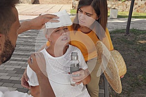 People helping woman on city street. Suffering from heat stroke