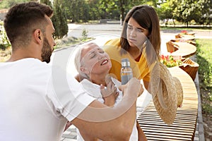 People helping woman on city street. Suffering from heat stroke