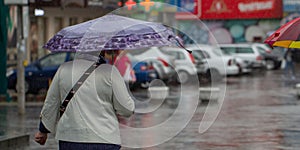 People hide from rain under umbrellas in a rainy day on the street of the city Bad weather concept