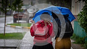 People hide from rain under umbrellas in a rainy day on the street of the city Bad weather concept