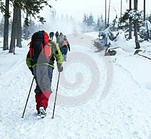 People hiking on snow trail in winter