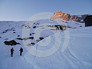 People hiking in wonderful winter landscape in Partnun at sunset. Praettigau, Graubuenden, Switzerland.