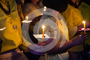 People hold candles light at night