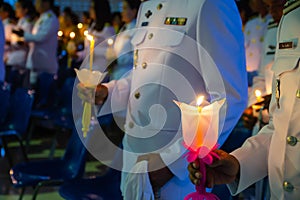 People hold candles light at night