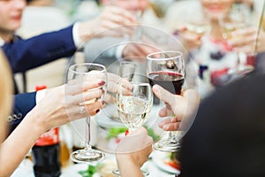 People hold in hands glasses with white and red wine