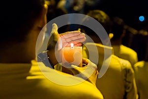 People holding candle vigil in darkness seeking hope, worship, p
