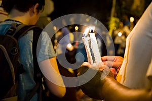 People holding candle vigil in darkness seeking hope, worship, p photo