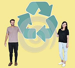 People holding a green recycling symbol