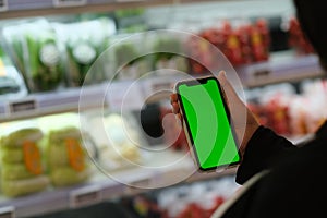 People holding green screen smart phone in grocery store