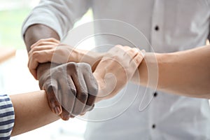 People holding hands on light background