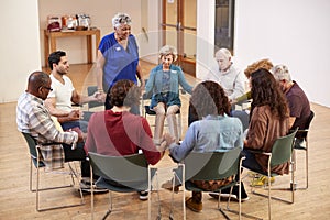 People Holding Hands And Praying At Bible Study Group Meeting In Community Center