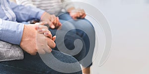 People holding hands while sitting in trust circle during therapy session