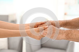 People holding hands together on blurred background, . Help and elderly care concept