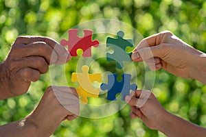 People holding multicolor jigsaw puzzle in hands