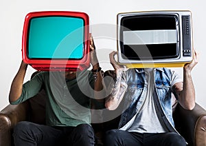 People holding retro television next to each other