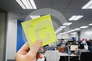 People holds postit with job interview reminder in office