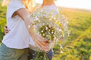 People, homosexuality, same-sex marriage and love concept - close up of happy lesbian couple with flower bunch on nature