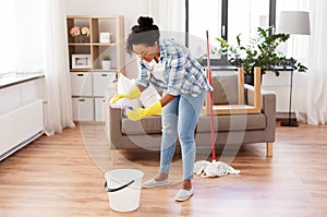 African woman or housewife cleaning floor at home