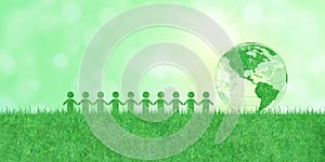 People or Human icons and green earth or globe on artificial grass with sunlight in background.