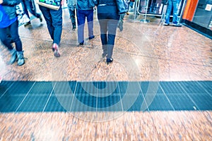 People in a hurry going into subway, blurred movement, focus on legs