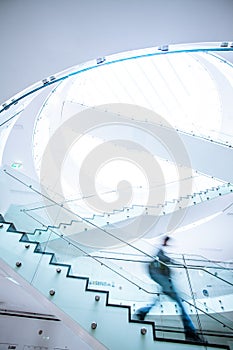 People inside a modern building walking up the stairs