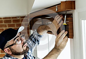 People installing window curtain apartment