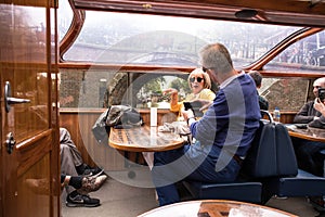 People on interior seating inside a glass roofed sightseeing canal cruise trip boat for tourists