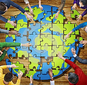 People with Jigsaw Puzzle Forming Globe in Photo photo