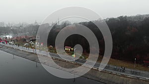 People jogging at running race championship. Female and male runners intense run along bank of river. Professional athletes hard t