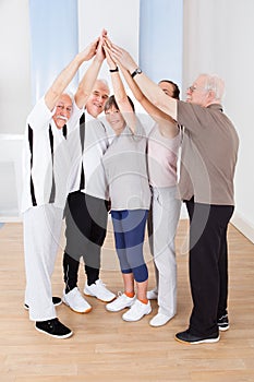 People joining hands together at gym