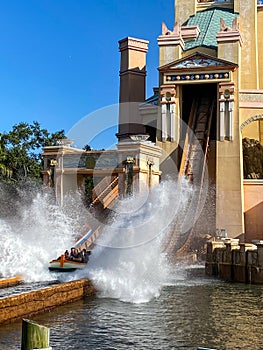 People on the Journey to Atlantis Roller Coaster water ride at SeaWorld speeding around the track and splashing into the water