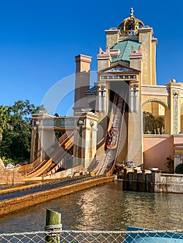 People on the Journey to Atlantis Roller Coaster water ride at SeaWorld speeding around the track and splashing into the water