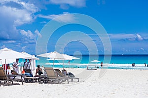 People joying sunlight at Cancun beach in Caribbean Sea. Exotic Paradise. Travel, Tourism and Vacations Concept