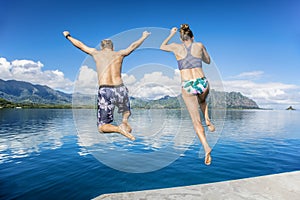 People jumping into the ocean while on a beautiful scenic Hawaiian vacation