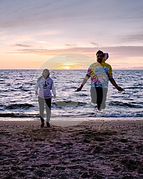 People with jumprope exersise on the beach, couple men and woman exersise together outsied on the beach in the photo