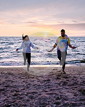 People with jumprope exersise on the beach, couple men and woman exersise together outsied on the beach in the photo