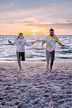 People with jumprope exersise on the beach, couple men and woman exersise together outsied on the beach in the photo