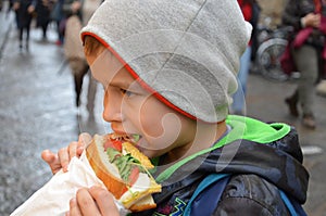 People, junk food, eating and lifestyle - close up of young man, boy with sandwich eating and drinking on city street