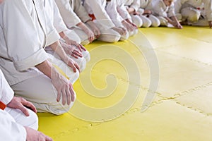 People in kimono sitting on tatami on martial arts training